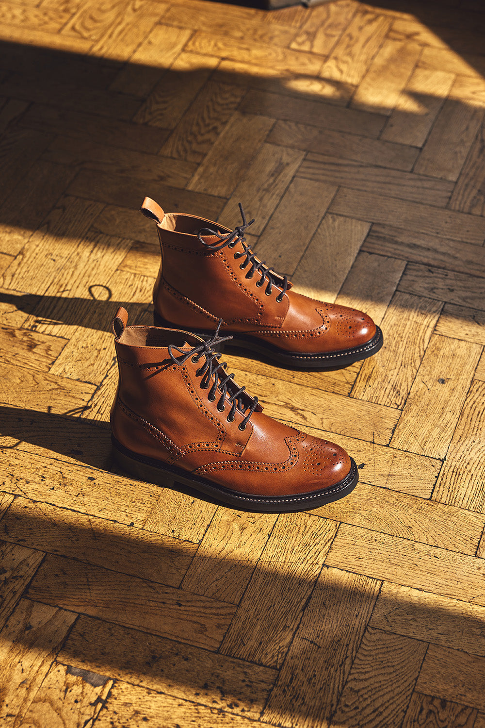Pair of brown leather boots on a wooden floor